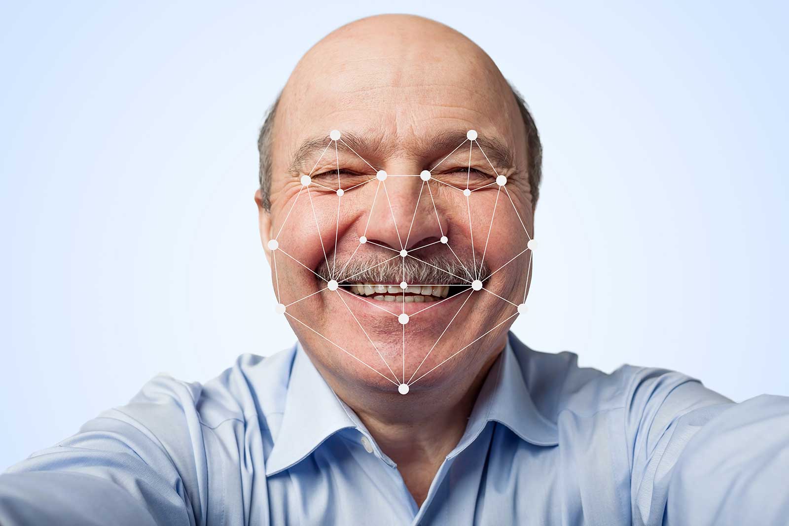 Imagem de uma pessoa sênior fazendo reconhecimento facial.
