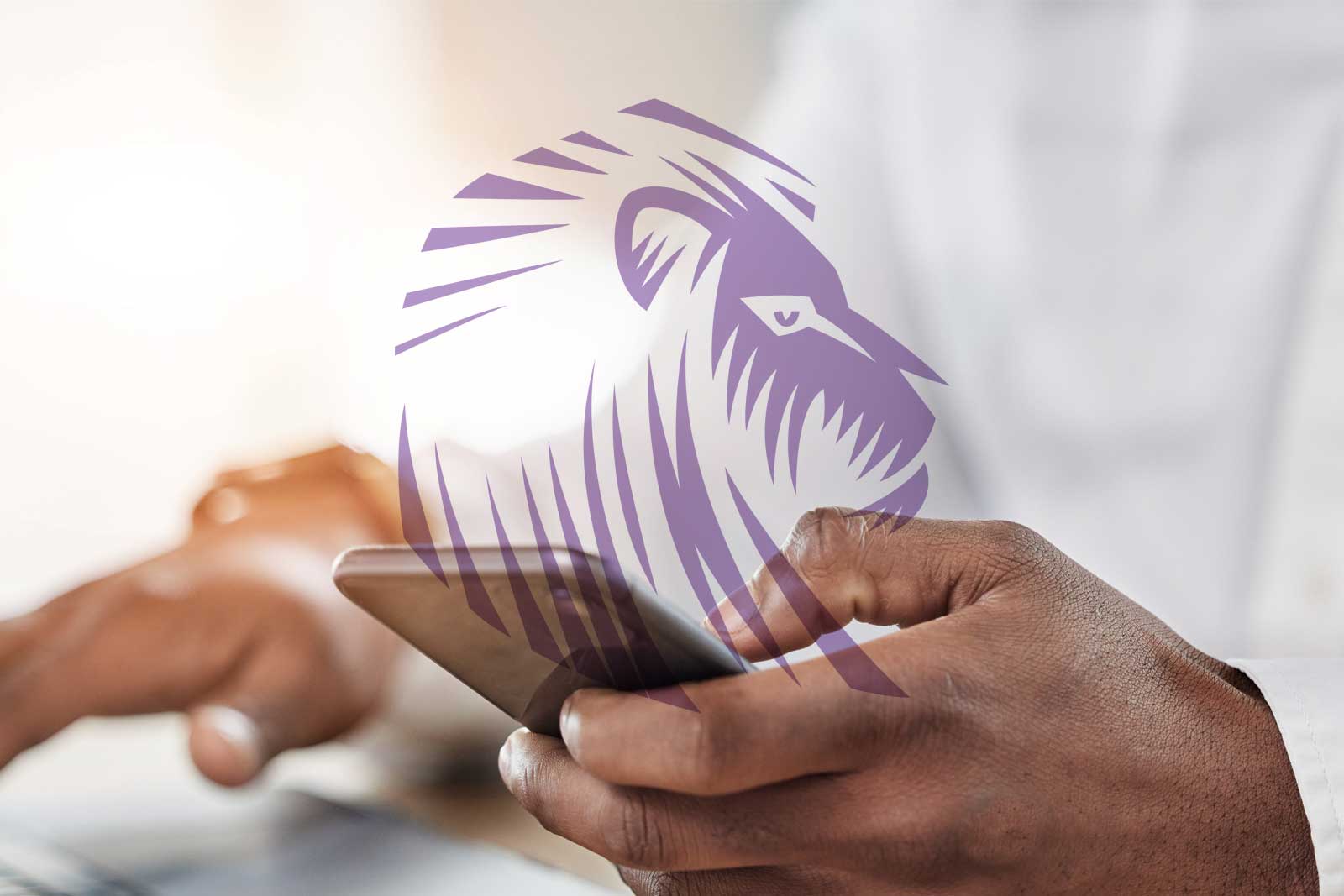 Imagem de uma pessoa usando um smartphone e um notebook, com um desenho de leão sobreposto.